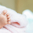 Newborn baby feet on a white blanket. - Краевое профобъединение