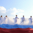 На изображении семь человек в белых рубашках стоят на фоне российского флага под голубым небом с облаками., Изображение. - Правительство Челябинской области