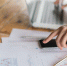 business-woman-hand-with-financial-charts-laptop-table - Новый Компаньон