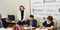 На фото деловая встреча в конференц-зале Южно-Уральской торгово-промышленной палаты: несколько человек в деловой одежде сидят за большим столом и подписывают документы, Изображение. - Правительство Челябинской области