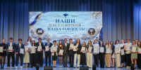 Выпускники стоят на сцене средней общеобразовательной школы №41 с благодарственными письмами в руках во время торжественного приема Главы города Вологды. - Администрация г. Вологда