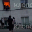 Александр удерживает женщину в окне, в ожидании людей, которые её поймают. Рядом на асфальте лежит второй пострадавший.  | Скриншот видеозаписи - Klops.Ru