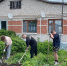 На фото - трое молодых людей участвуют в благоустройстве придомовой территории возле жилого дома, Изображение. - Правительство Челябинской области