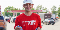 Волонтер держит в руках бутылки с водой на фоне автомобилей. - Администрация г. Вологда