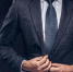 cropped-portrait-of-a-successful-businessman-buttoning-his-elegant-suit-isolated-on-a-dark-background - РИА 7 Новостей
