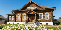 деревянный дом культуры, перед ним клумба с ромашками - Петрозаводск говорит
