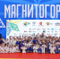 Группа людей в спортивной форме на фоне сцены с надписью «Магнитогорск», Изображение. - Правительство Челябинской области