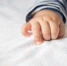 Newborn baby hand in white bed. Selective focus. - Краевое профобъединение