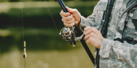 man-fishing-holds-angling-rod_1.jpg - GorodnaBire.Ru
