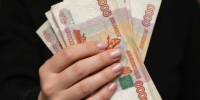 пачка российских купюр в руке - Петрозаводск говорит