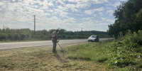 Участник экоакции косит сорную растительность - Министерство природных ресурсов
