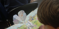 школьник изучает книжку-игрушку про Бородинское сражение - Библиотека для незрячих и слабовидящих