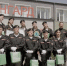 На фото — группа молодых людей в форменной одежде с беретами и белыми перчатками позирует на фоне здания с надписью «АВАНГАРД»: участники держат грамоты, награды и зелёные подарочные пакеты, рядом установлены флаги. - Коркинский муниципальный округ