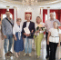 На фото — группа из девяти взрослых и одной девочки в торжественном зале ЗАГСа: в центре мужчина с документом, рядом женщина с букетом, остальные участники позируют для совместного снимка. - Коркинский муниципальный округ
