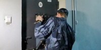 Сотрудник в камуфляжной форме открывает металлическую дверь с номером 26 - 168.Ru