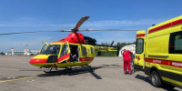 Медицинский вертолет и автомобиль скорой помощи на аэродроме, рядом медработник с каталкой - 168.Ru