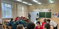 Школьный класс: группы подростков за партами, часть в красных футболках, часть в тёмной форме; две женщины стоят у доски. - 168.Ru