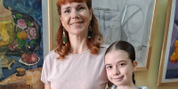Девочка держит диплом с крупным заголовком «ДИПЛОМ», рядом взрослая женщина; на стене за ними висят оформленные картины. - 168.Ru