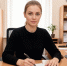 Сотрудница за офисным столом заполняет документ рядом со стопкой папок, компьютером и телефоном - 168.Ru