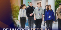 несколько подростков (старшеклассников) в холле кампуса с бейджами; в кадре логотипы СКОЛКОВО и МФТИ и рекламный текст о кейс-чемпионате с датой регистрации - 168.Ru