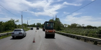 На фото каток на фоне дороги и автомобиль - Министерство транспорта