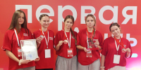 Пять девушек в одинаковых красных футболках на фоне красного баннера с надписью «первая», держат медали, диплом и стеклянный приз - 168.Ru
