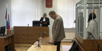 Зал суда: судья у скамьи, мужчина у стола и человек в металлической клетке справа - 168.Ru
