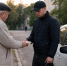пожилой мужчина передаёт пачку наличных молодому мужчине рядом с автомобилем с шашечкой такси на городской улице - 168.Ru