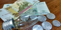 лампочка на столе рядом с российскими банкнотами и монетами - 168.Ru