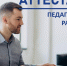 На фото — мужчина в серой рубашке сидит за рабочим столом перед компьютером, на фоне крупно размещена надпись «Аттестация педагогических работников». - Министерство образования и науки