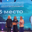 На сцене три женщины — участницы IX Всероссийского конкурса «Учитель‑дефектолог России — 2026»: одна из них держит диплом за 3‑е место в номинации «Дефектолог года», другая — букет, на фоне — экран с оформлением конкурса и портрет участницы. - Министерство образования и науки