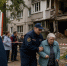 Спасатели помогают пожилой женщине на фоне повреждённого многоквартирного дома и пожарной машины - 168.Ru