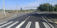 На фото перекрёсток (по одной полосе в каждом направлении), на переднем плане пешеходный переход, на перекрёстке нанесена дорожная разметка, слева на фото дорожная техника - Министерство транспорта