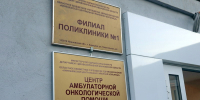 Стена у входа с двумя металлическими табличками: «Филиал поликлиники №1» и «Центр амбулаторной онкологической помощи», на табличках виден адрес «ул. Текстильная, д.6»; водяной знак www.168.ru. - 168.Ru