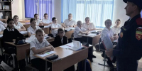 На фото — ученики сидят за партами, пожарный в классе общается с детьми - Министерство гражданской обороны и чрезвычайных ситуаций