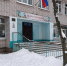 Вход в сельскую школу зимой: крыльцо с перилами, флаг России и сугробы у стен - Newsroom24.Ru