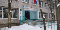 Вход в сельскую школу зимой: крыльцо с перилами, флаг России и сугробы у стен - Newsroom24.Ru
