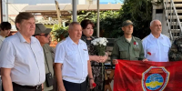 На фото — группа людей (мужчины в гражданской одежде и военной форме, женщина с букетом белых цветов) на улице у здания; двое мужчин держат красное полотнище с эмблемой «Краснодарское региональное отделение». - Министерство образования и науки
