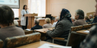 Пожилая женщина слушает лекцию врача в аудитории в Нижегородской области - Newsroom24.Ru