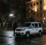 Полицейский внедорожник ночью у ограды освещённого здания на пустой площади - Newsroom24.Ru