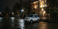 Полицейский внедорожник ночью у ограды освещённого здания на пустой площади - Newsroom24.Ru