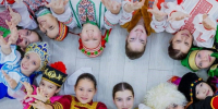 Дети разных национальностей лежат в круге на полу в национальных костюмах.. - Администрация г. Вологда