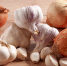 Pile of whole onions and garlic bulbs and cloves on a wooden table - Газета Восход