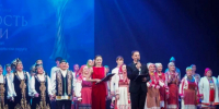 на сцене группа людей в народных костюмах, двое ведущих. - МО Кирово-Чепецк