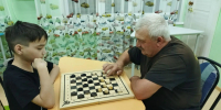 Два поколения встретились за шашечной доской в приюте «Забота» - Министерство труда