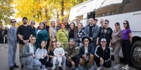 Групповая фотография труппы/коллектива у белого пассажирского автобуса на улице, осенний день. - 168.Ru