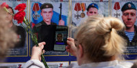 Женщина навела камеру телефона на изображение героя СВО на стенде проекта «Дополненная героическая реальность. Парк Победы».. - Администрация г. Вологда