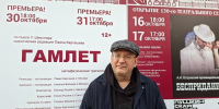 Мужчина на фоне афиши спектакля «Гамлет» с крупной надписью и датами премьер 30 и 31 октября у оформления театра. - 168.Ru