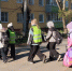 Группа младших школьников в световозвращающих жилетах переходит дорогу по пешеходному переходу, у детей рюкзаки. - 168.Ru