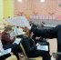В зале школьники сидят в рядах с распечатками, на которых видны QR‑коды; ведущая протягивает лист с QR‑кодом. - 168.Ru
